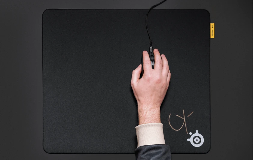 personne tenant une souris de jeu