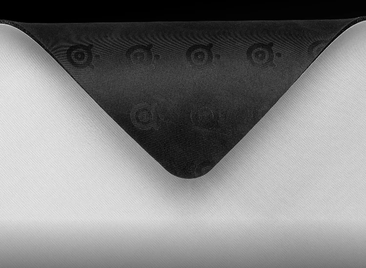 Close-up of the SteelSeries QcK Heavy XXL mousepad showing the non-slip rubber base with embossed SteelSeries logos designed to prevent unwanted movement during gaming.