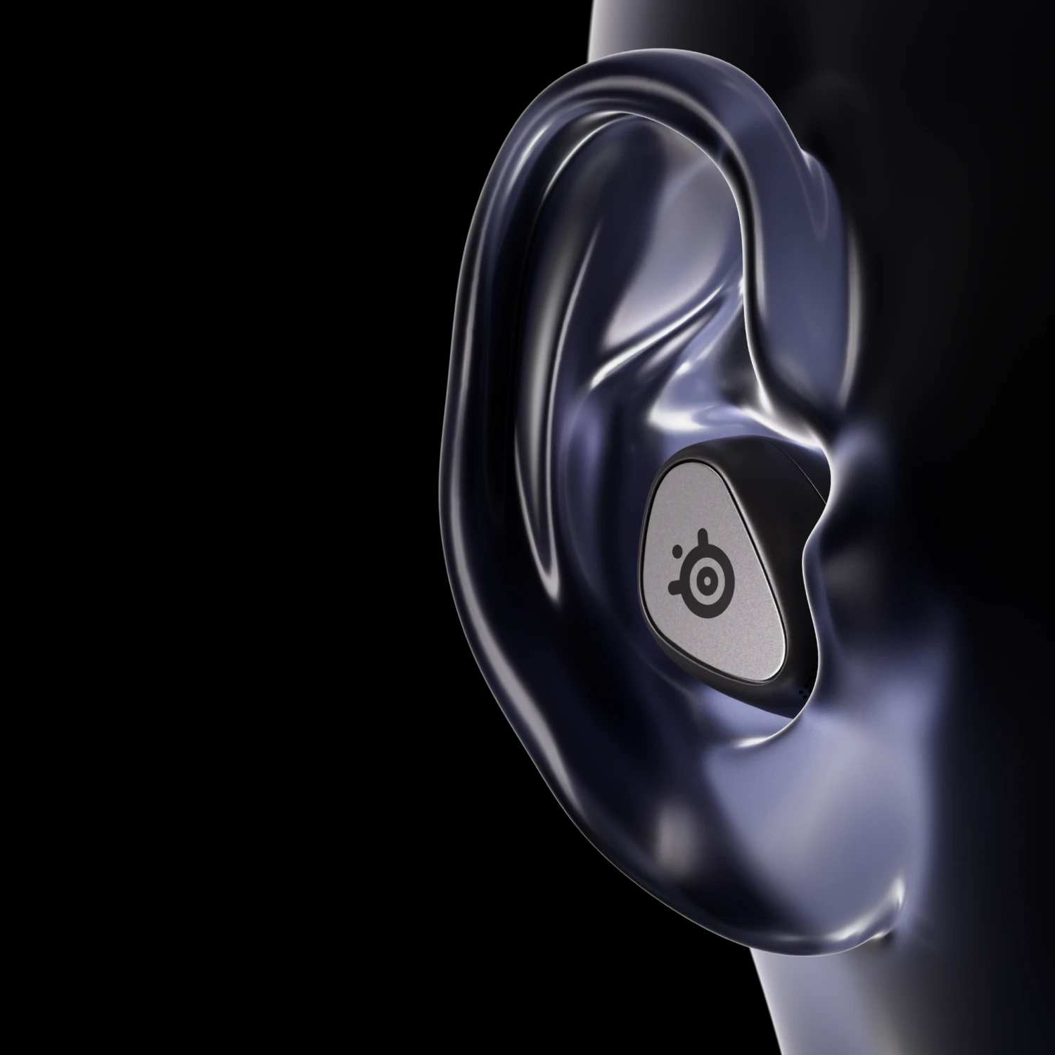 Se ve la oreja grande del maniquí con unos audífonos Arctis Gamebuds negros.