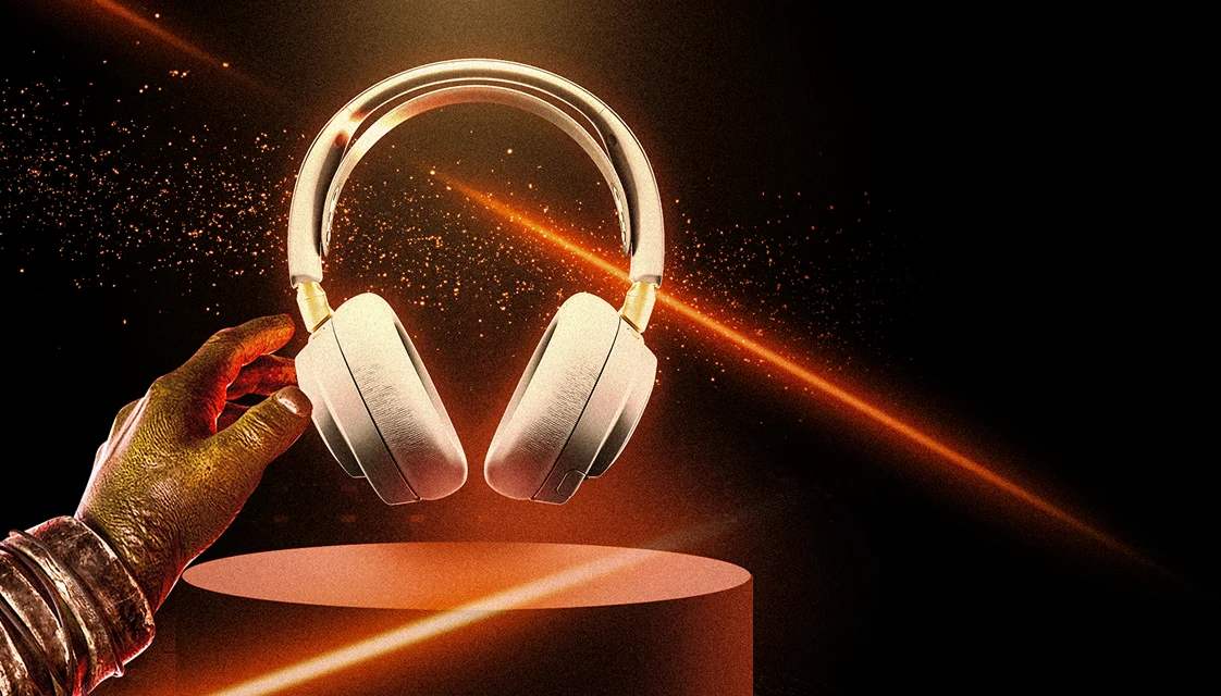 Et billede af Arctis Nova Elite vist på en piedestal med orange laserlys, der oplyser baggrunden.