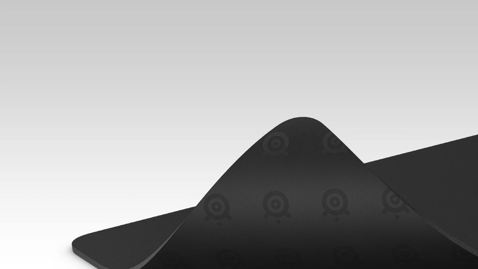 A large, bent QcK mousepad; its underside and rubber base are visible.