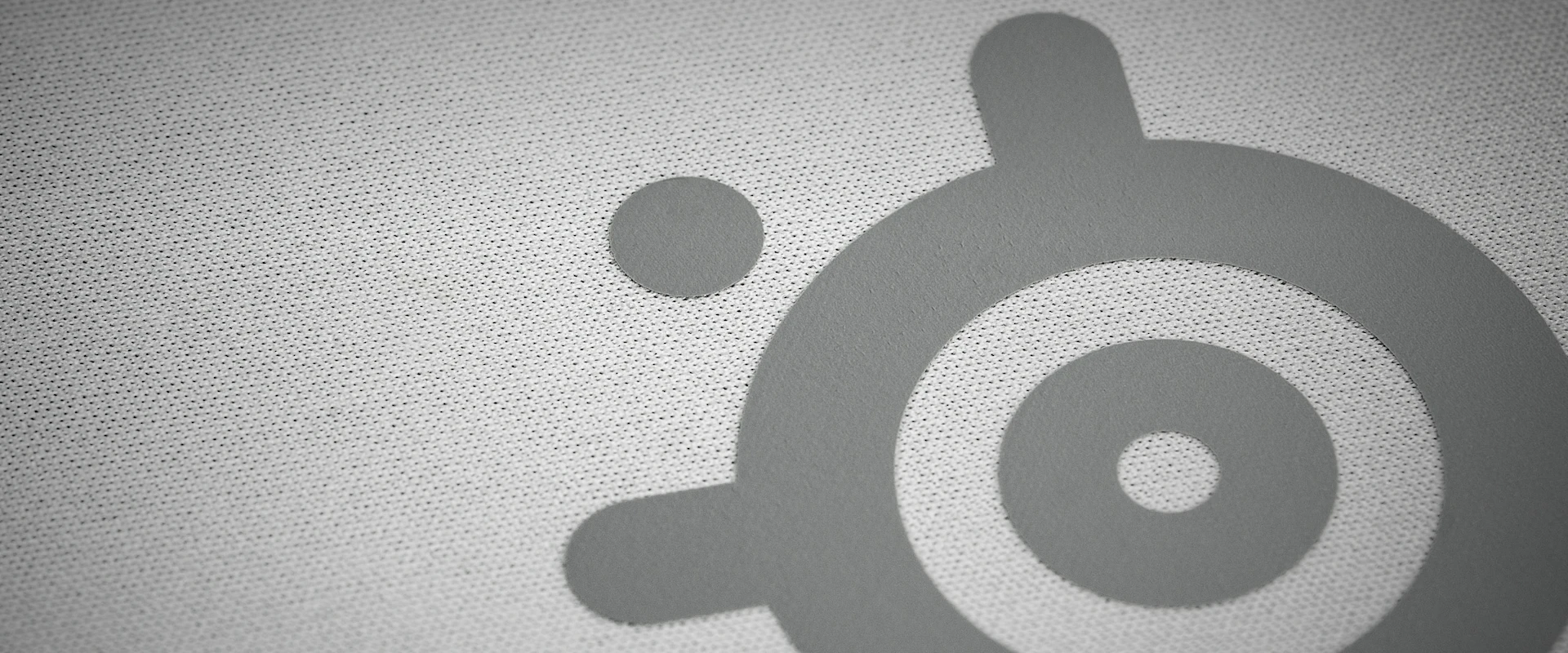 Extreme close-up of the high thread count micro-woven cloth surface on the white SteelSeries QcK Heavy XXL, optimized for both optical and laser sensor tracking accuracy.
