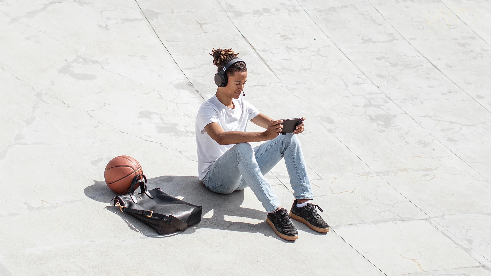 Person wearing Arctis 1 headset sitting on a concrete floor