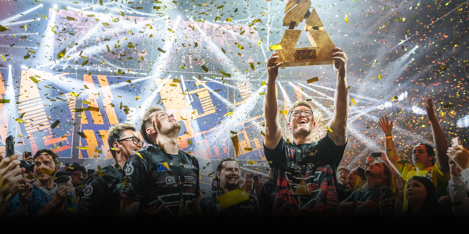 The FaZe clan members celebrating a win, holding a trophy.