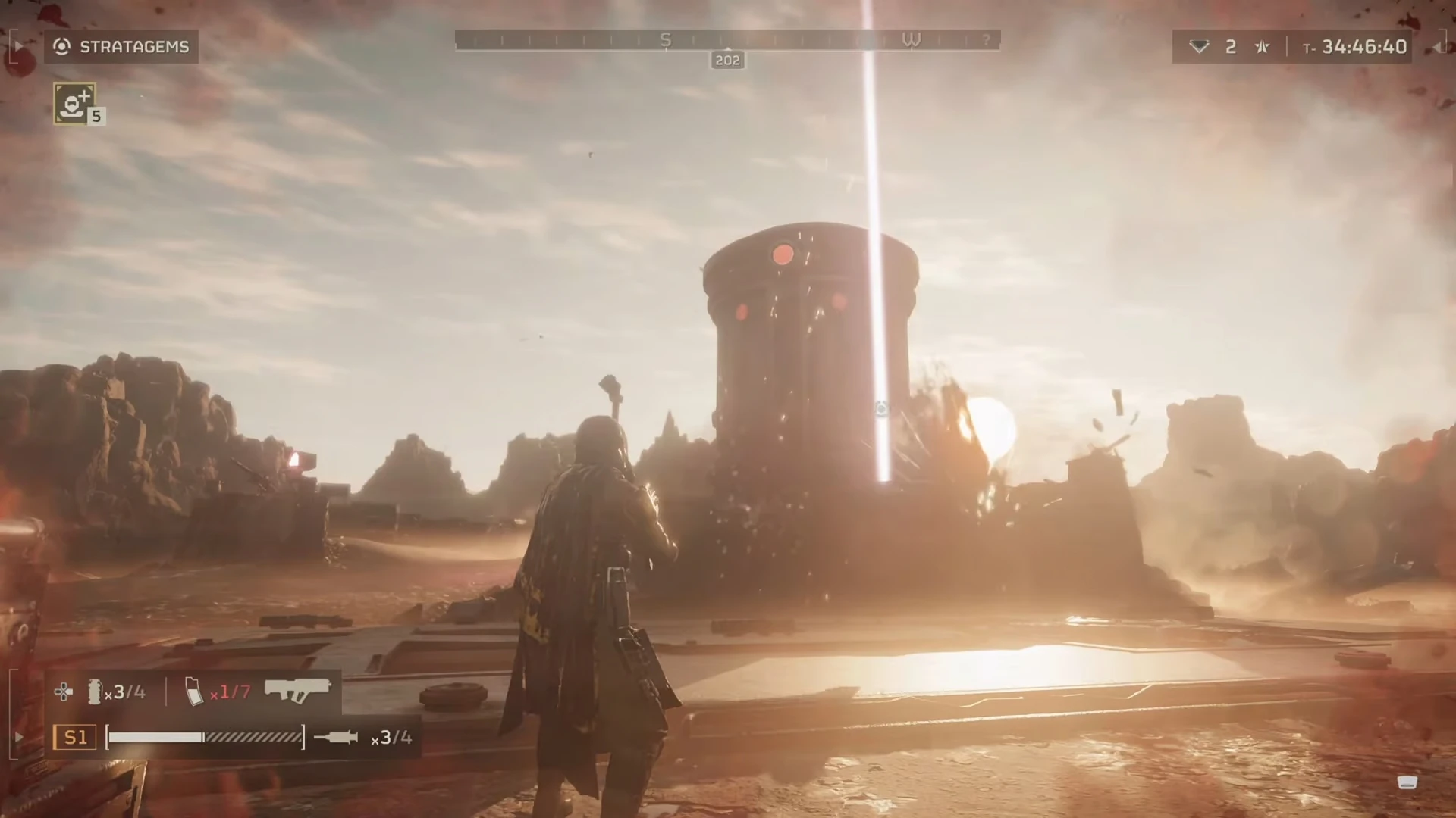 A character from Helldivers standing in front of a large silo, with a rising sun in the background.