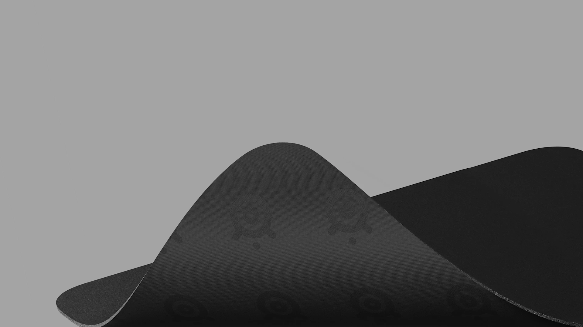 A large, bent QcK mousepad; its underside and rubber base are visible.