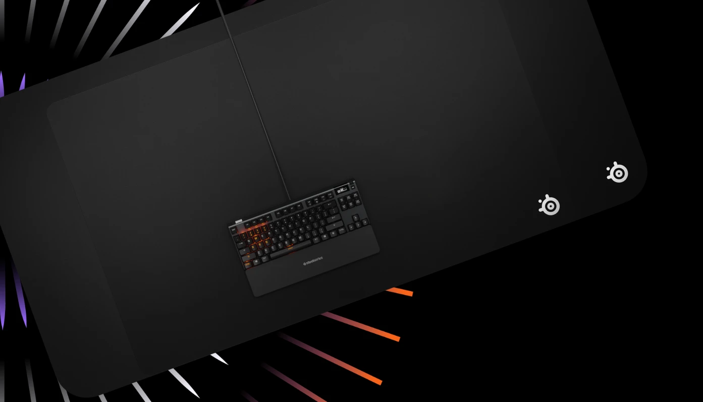 An image of the QcK 4XL, 5XL, and an Apex keyboard with a purple, grey, and orange burst in the background.