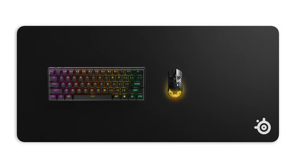A QCK mousepad on which a keyboard and a wireless mouse are resting.