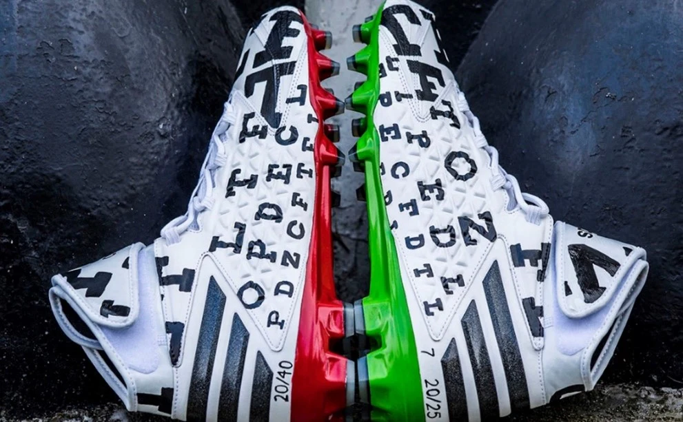 pair of shoes with letters on the sides and green and red soles. 