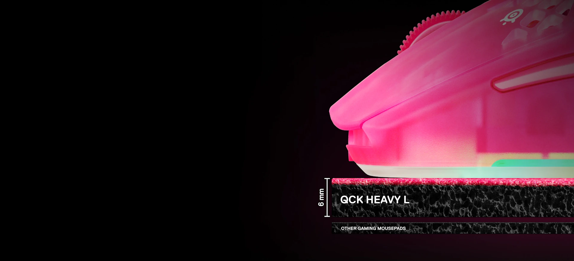 Et nærbillede fra siden, der viser tykkelsen på 6 mm på SteelSeries QcK Heavy XXL-musemåtten sammenlignet med tyndere standardmåtter, med en magenta gamingmus placeret ovenpå.