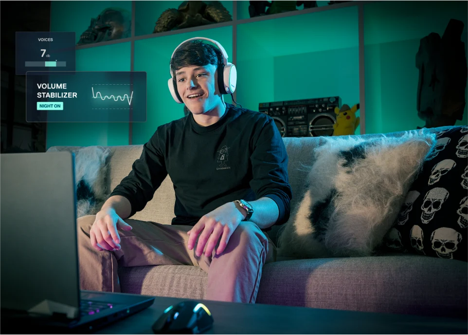 Man sitting in a sofa watching a movie on this laptop. Nahimic Volume stabilizer interface is displayed.