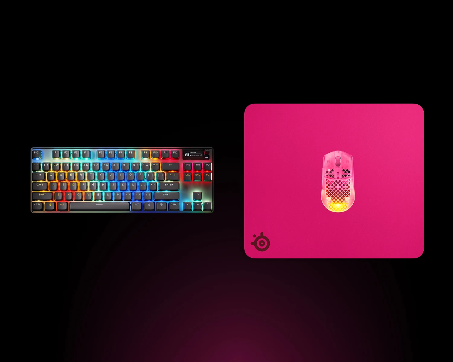 Ovenfra-billede af en magenta SteelSeries QcK Heavy XXL gaming-musemåtte med et RGB-mekanisk tastatur og en magenta Aerox gaming-mus.