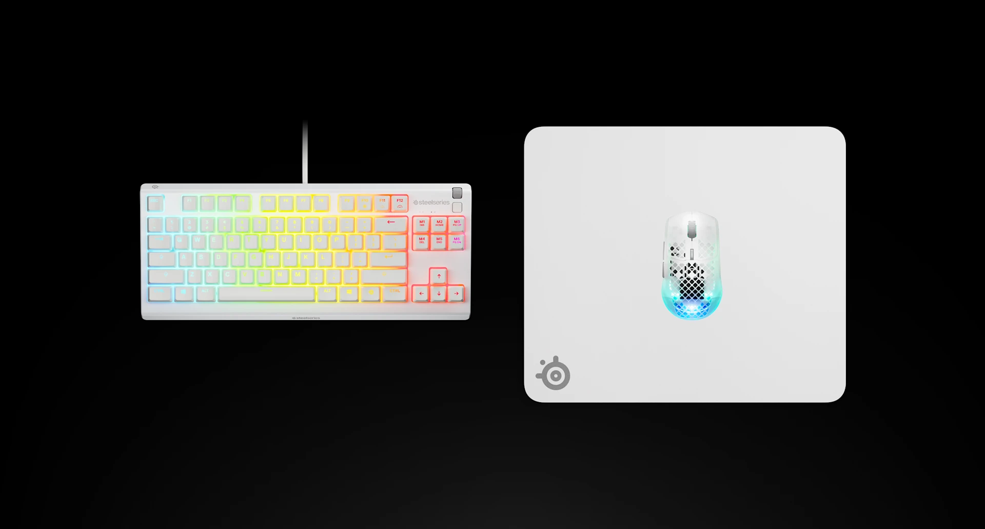 Widok z góry na białą podkładkę pod mysz SteelSeries QcK Heavy L z klawiaturą RGB i białą myszą Aerox na czarnej powierzchni.
