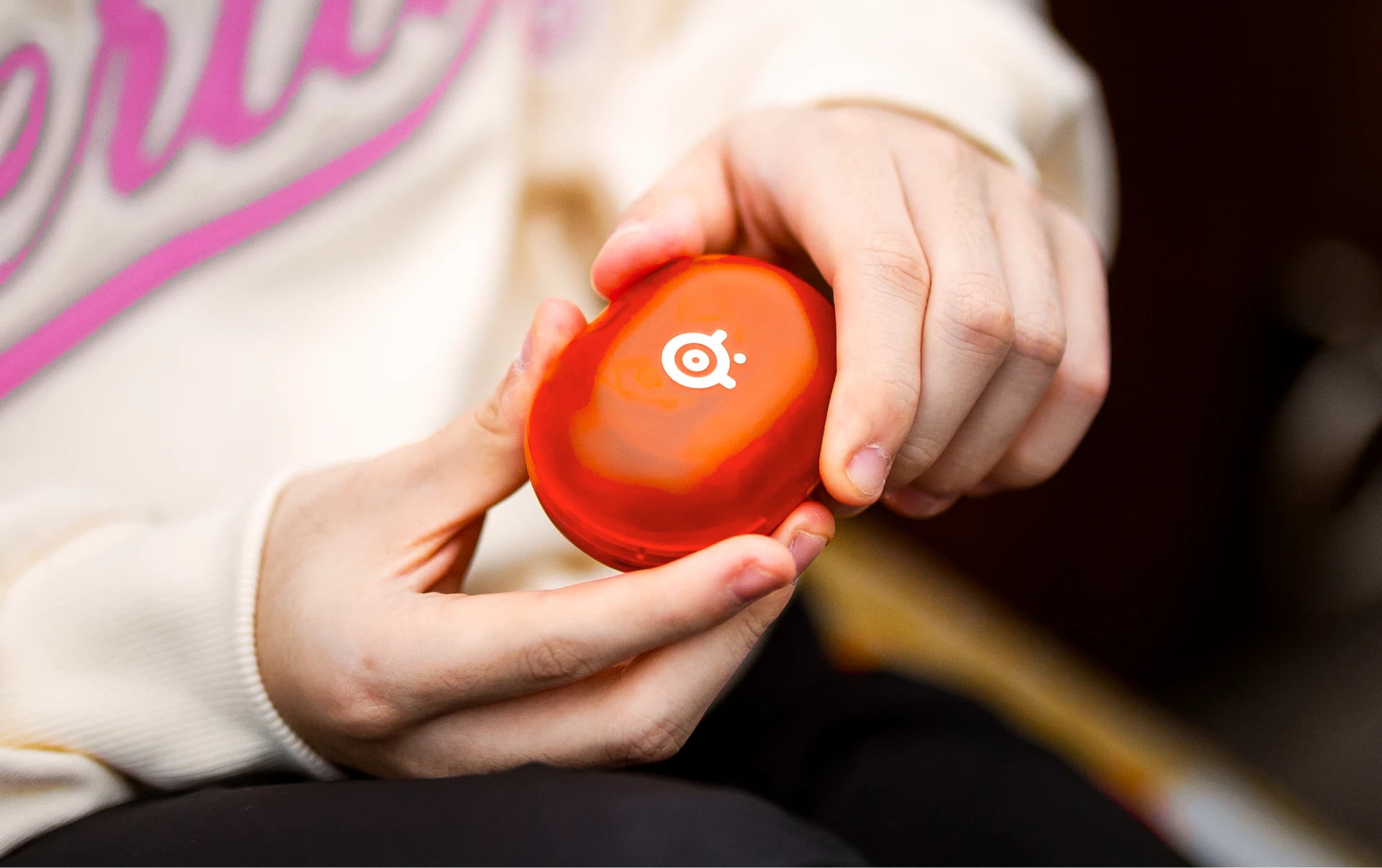 Uma visão dos Arctis Gamebuds em uma caixa laranja