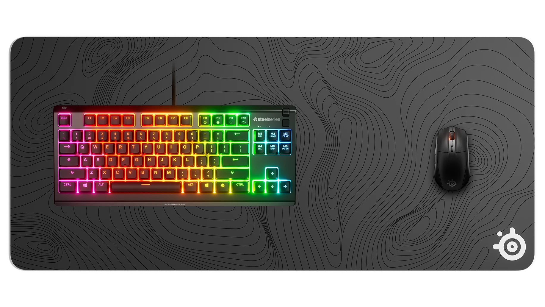 SteelSeries gaming mouse, topographic mousepad, and RGB mechanical keyboard.