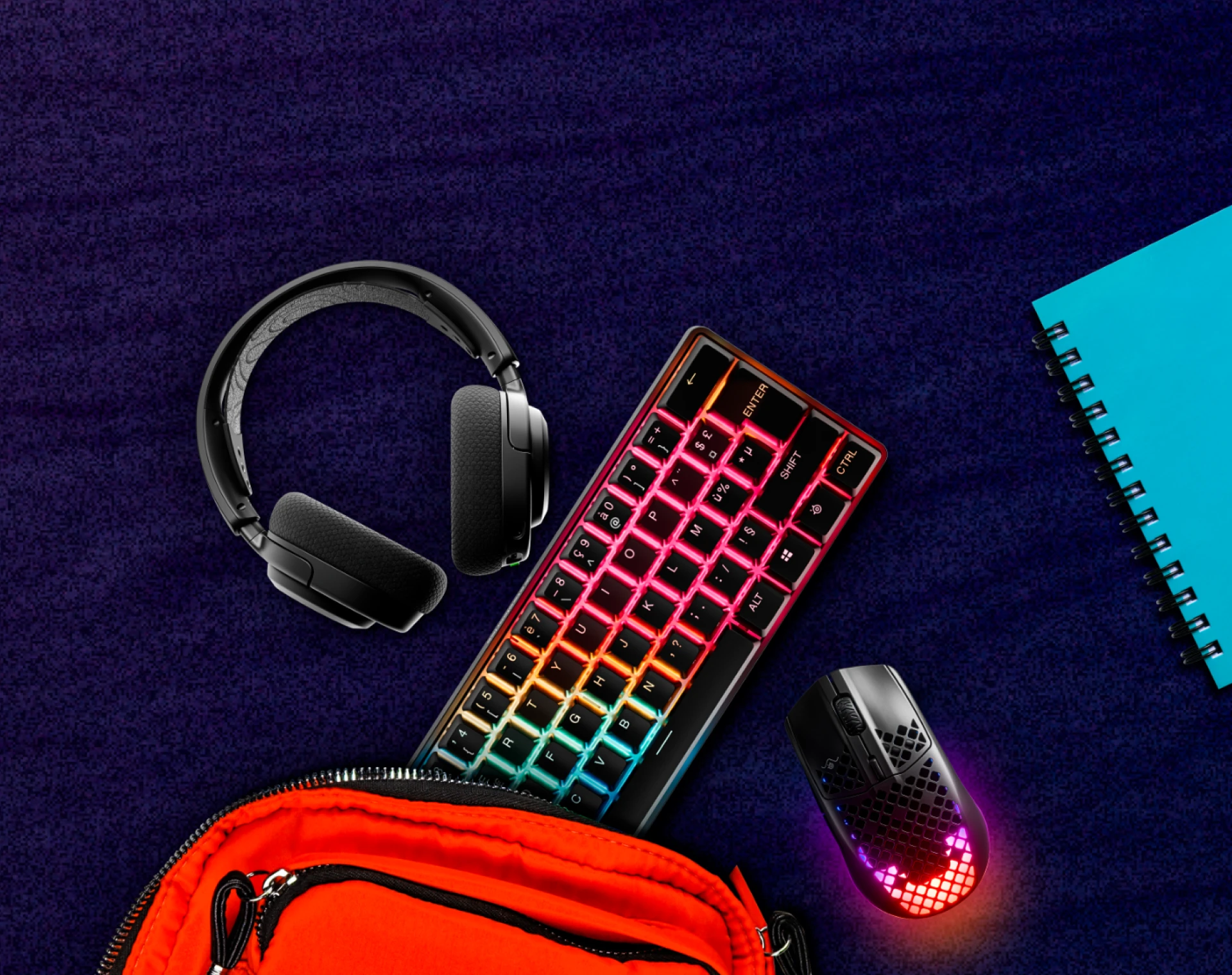 An image of assorted SteelSeries gear pictured with a backpack and notebook.
