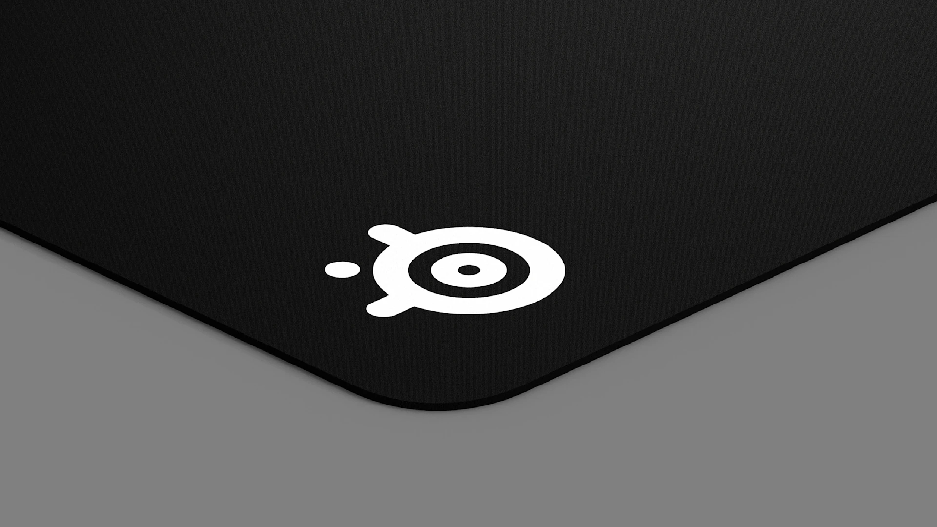 Close-up of the corner of the QcK mousepad, showing the SteelSeries logo