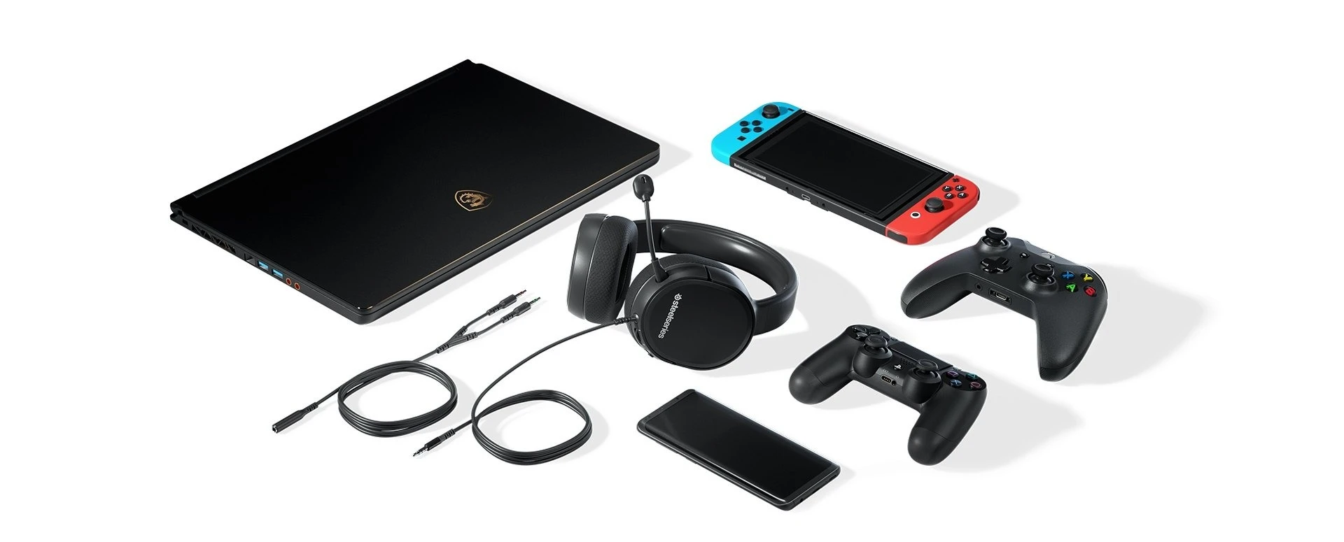 Le cuffie Arctis 1 sono circondate da dispositivi che possono essere collegati a