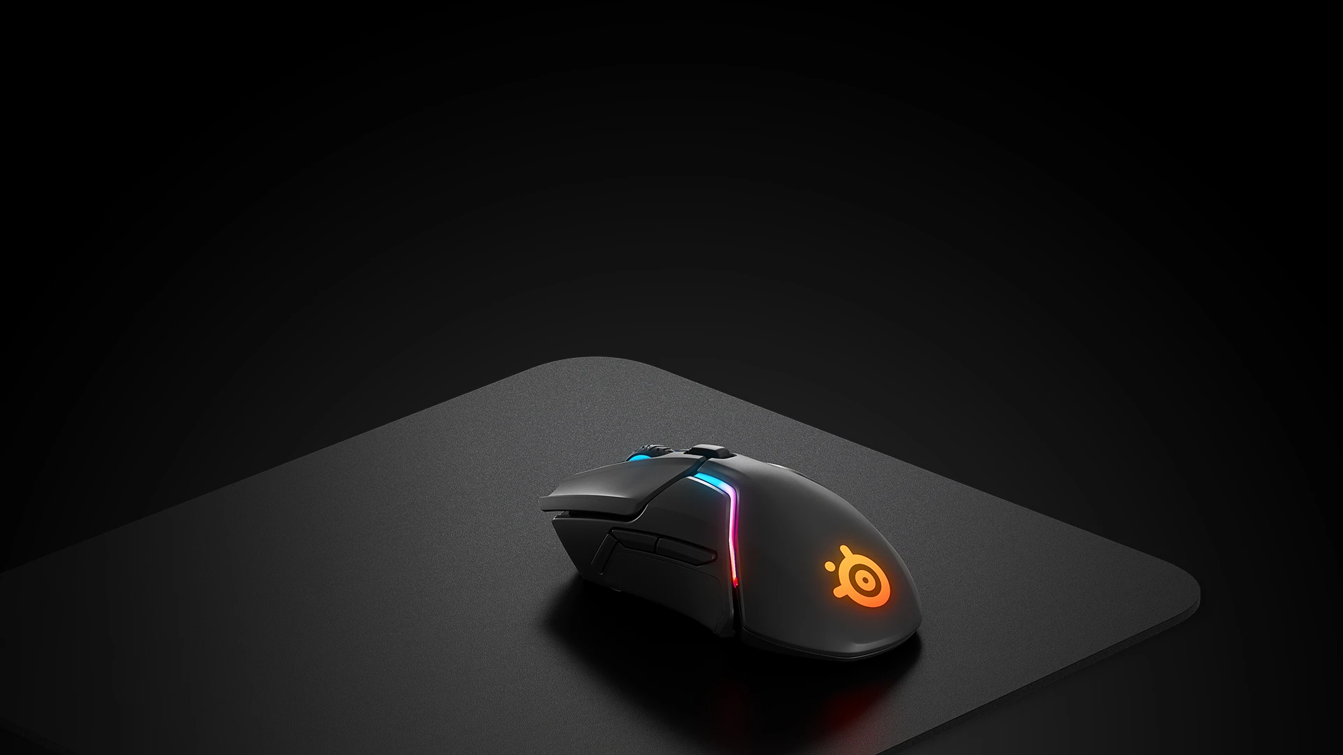 Il mousepad rigido QCK su cui è posizionato un mouse nero con illuminazione RGB