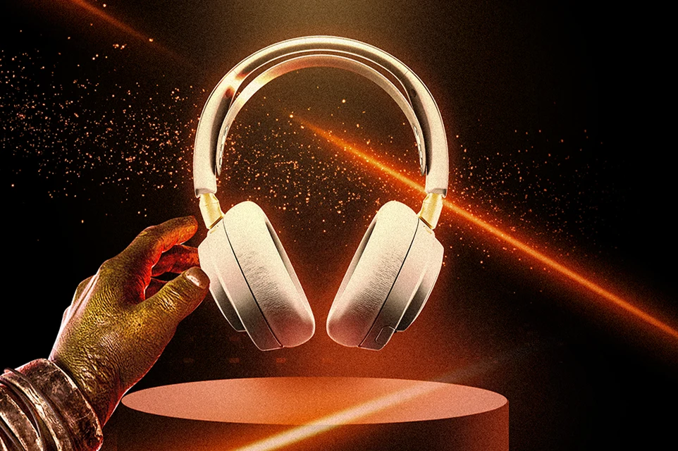 Et billede af Arctis Nova Elite vist på en piedestal med orange laserlys, der oplyser baggrunden.