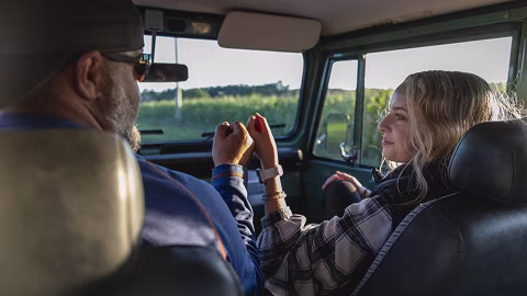 Father and daughter bond while on a road trip in a classic car.