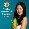 Woman holding Rosemary Mint Conditioner. Visibly removes oil & residue in 1 wash