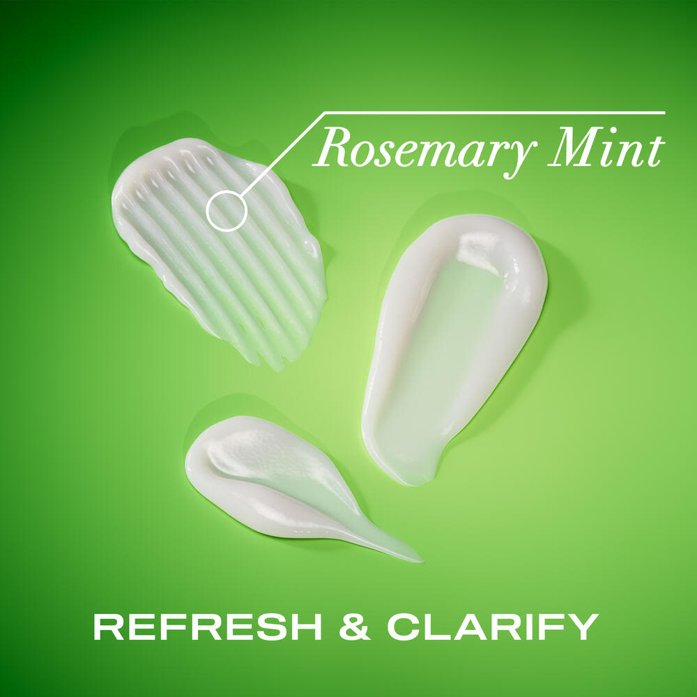 Traînées de revitalisant extra fort romarin et menthe OGX® sur un fond vert
