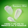 Traînées de revitalisant extra fort romarin et menthe OGX® sur un fond vert