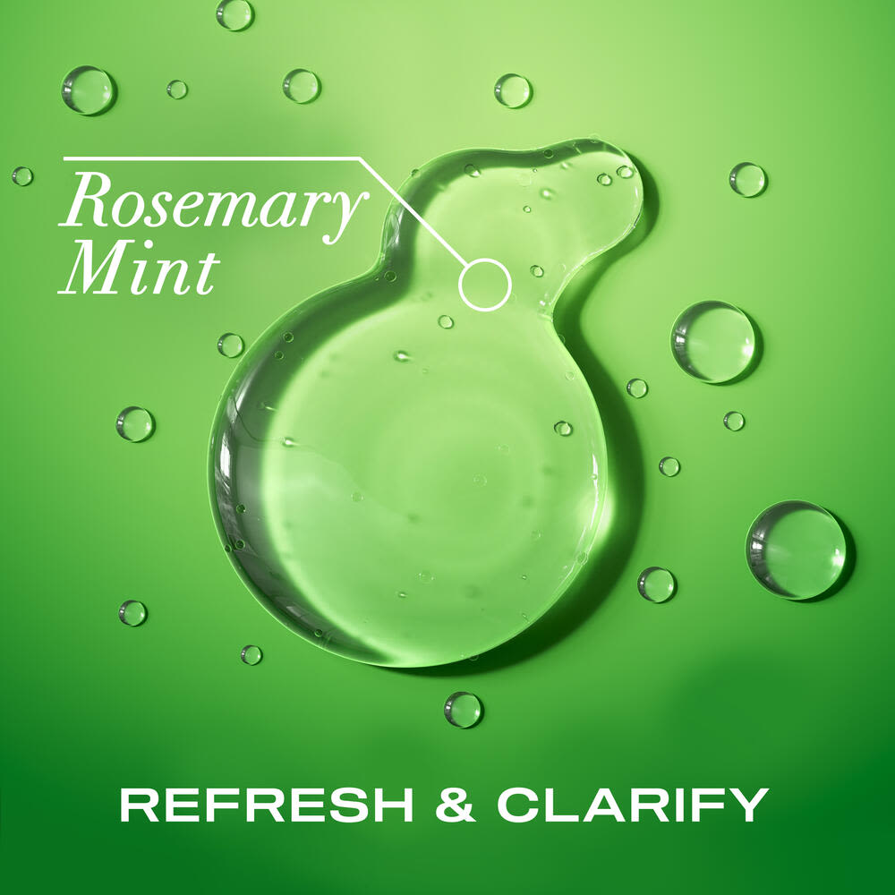 OGX® Rosemary Mint Extra Strength Shampoo product smear on a green background