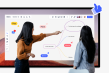 2 personnes devant un écran interactif et travaillant sur un tableau Miro qui affiche une carte mentale