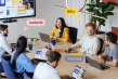 Plusieurs personnes en réunion dans un bureau et en vision avec un tableau Miro sur un écran interactif