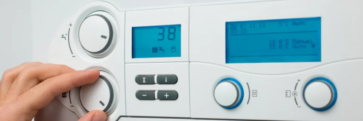 A person adjusting the settings on a combi boiler.