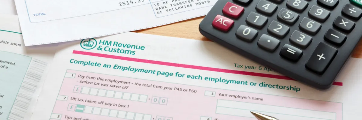 HMRC tax forms and a calculator on a table.