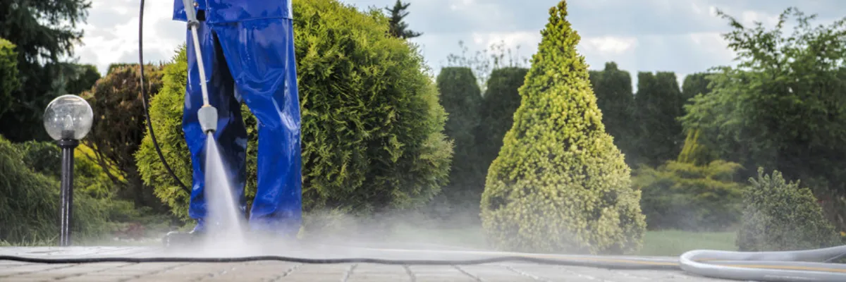A person cleaning a driveway with a pressure washer.