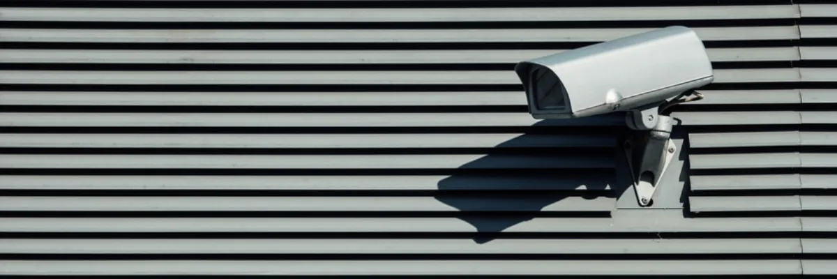A security camera situated on a metal wall.