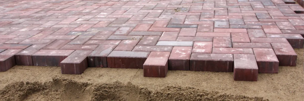 A red block paving installation, partway through installation.