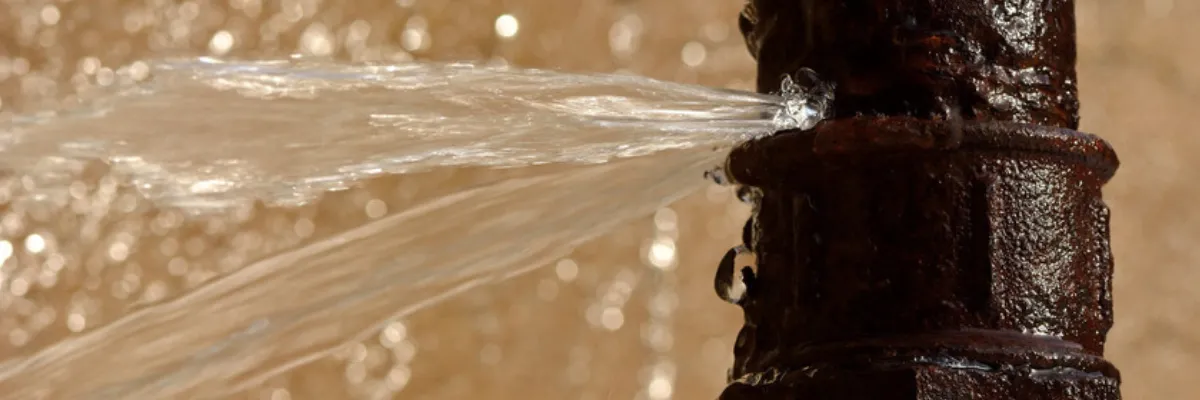 A burst pipe spraying water.