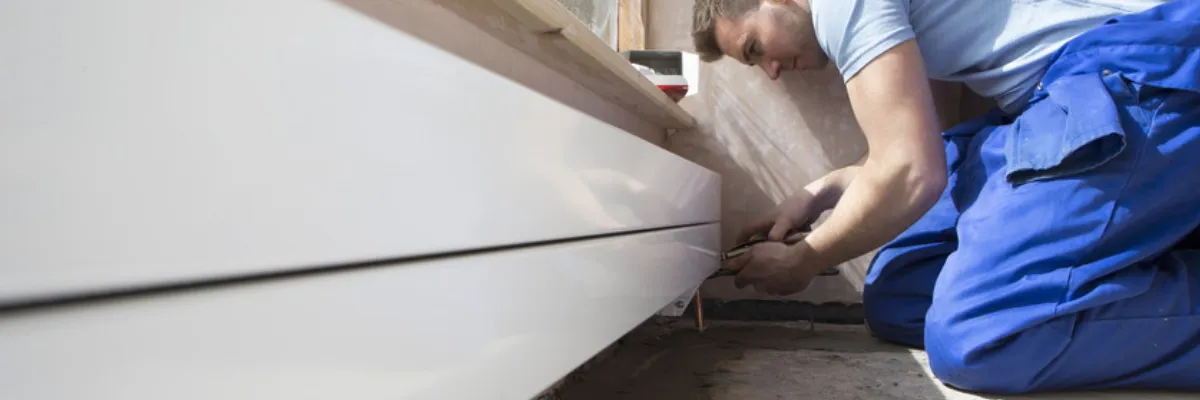 A heating engineer moving a radiator.