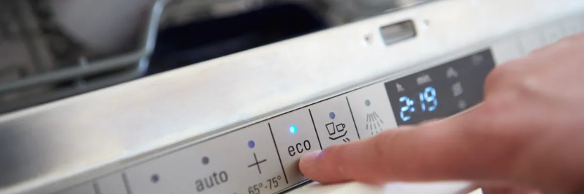A person turning on a dishwasher's eco mode.