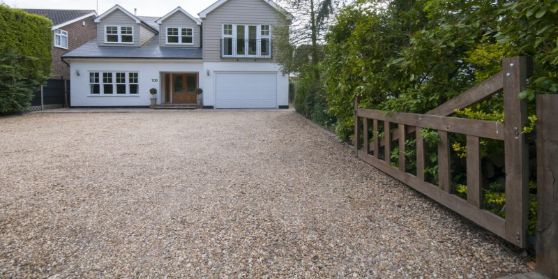 Gravel Driveway Article Image A large gravel driveway leading up to a house.