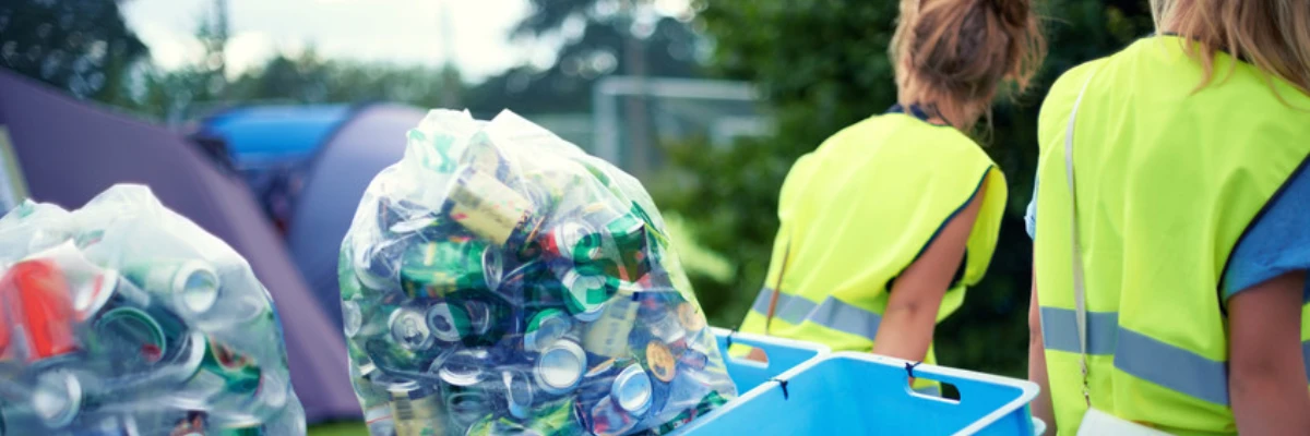 Two women removing bags of cans from a property.