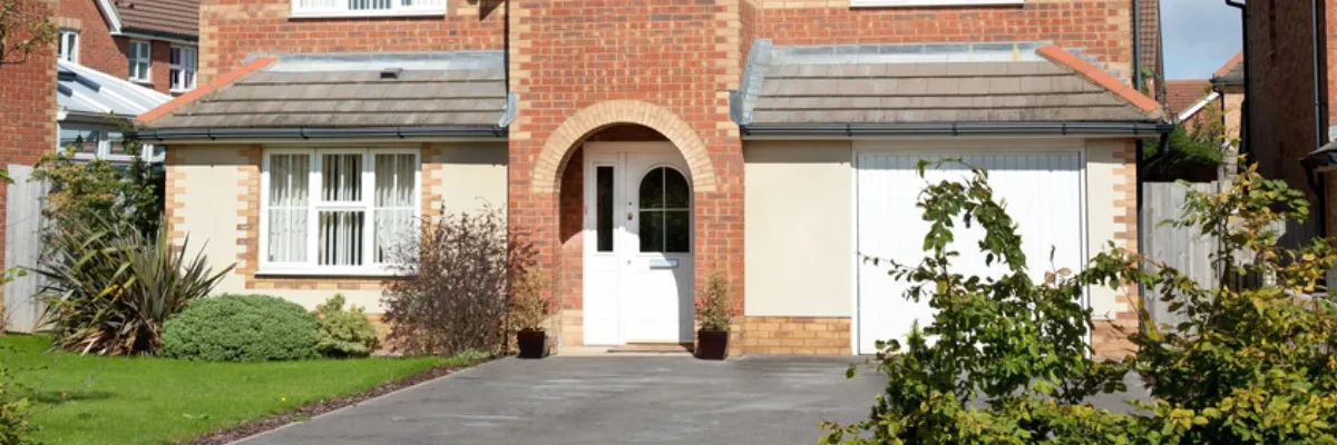 A house with an asphalt driveway in front of it.