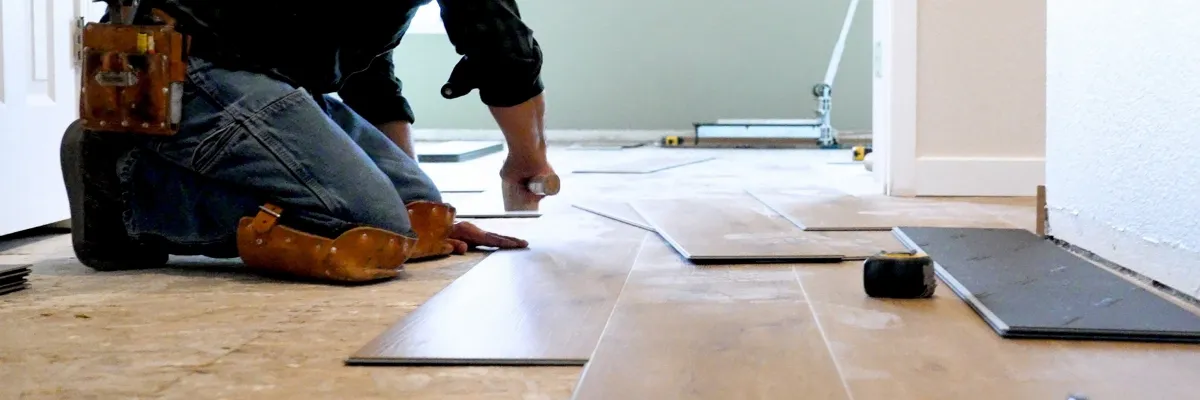 An installer laying laminate flooring.
