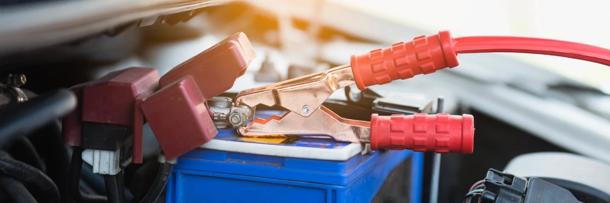 A close-up of a car battery connected to a wire.