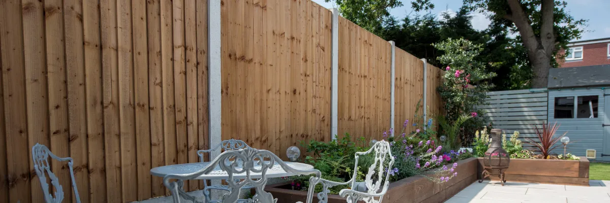 A garden fence with concrete fence posts.
