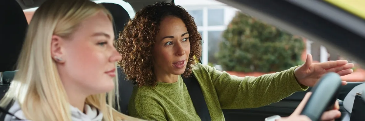 A female driving instructor teaching a learner driver.