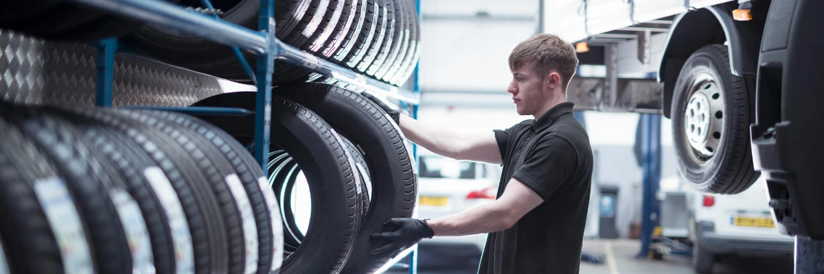 A tyre specialist removing a tyre from a rack.