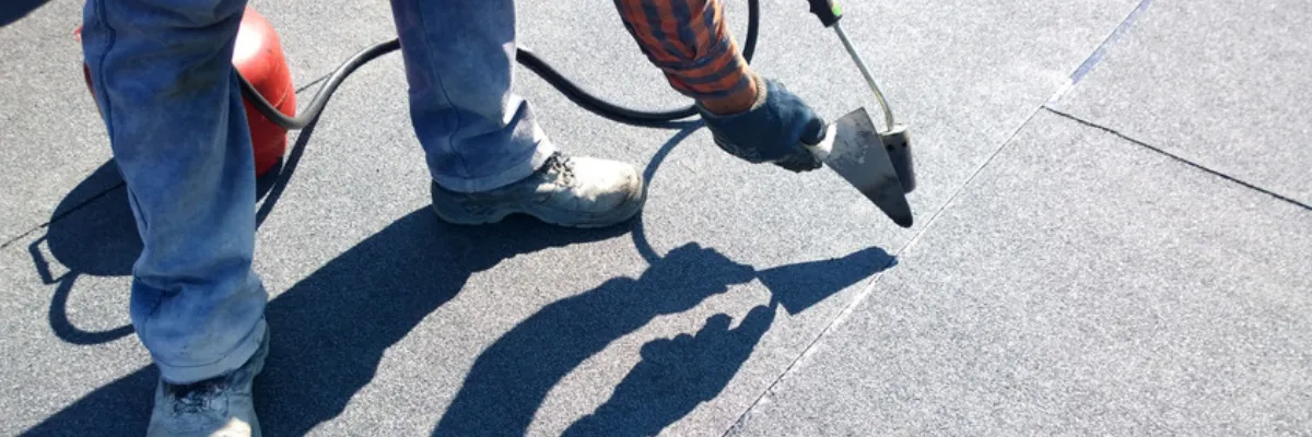 A roofing contractor installing a flat roof.