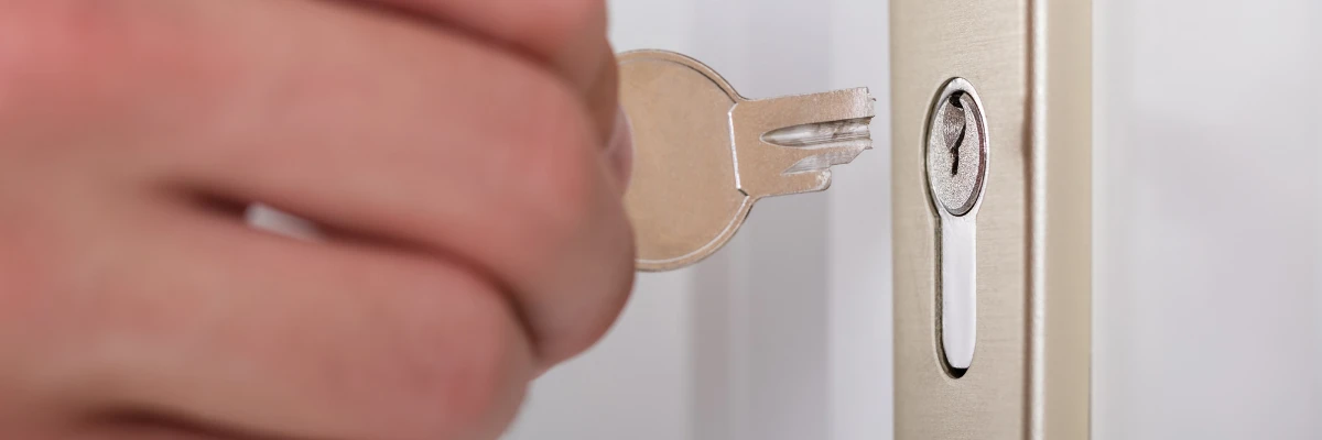 A broken key held close to a lock.