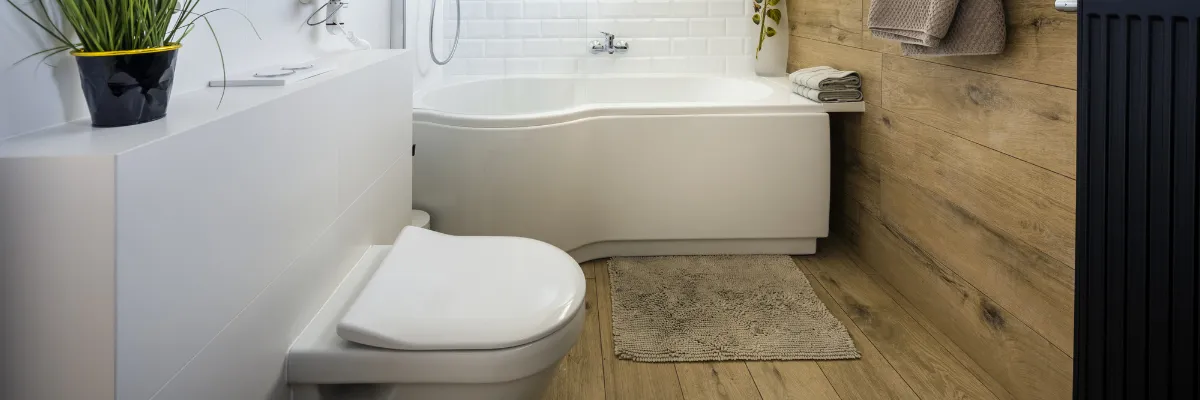 A bathroom with wooden features, white fittings, and concealed pipework.